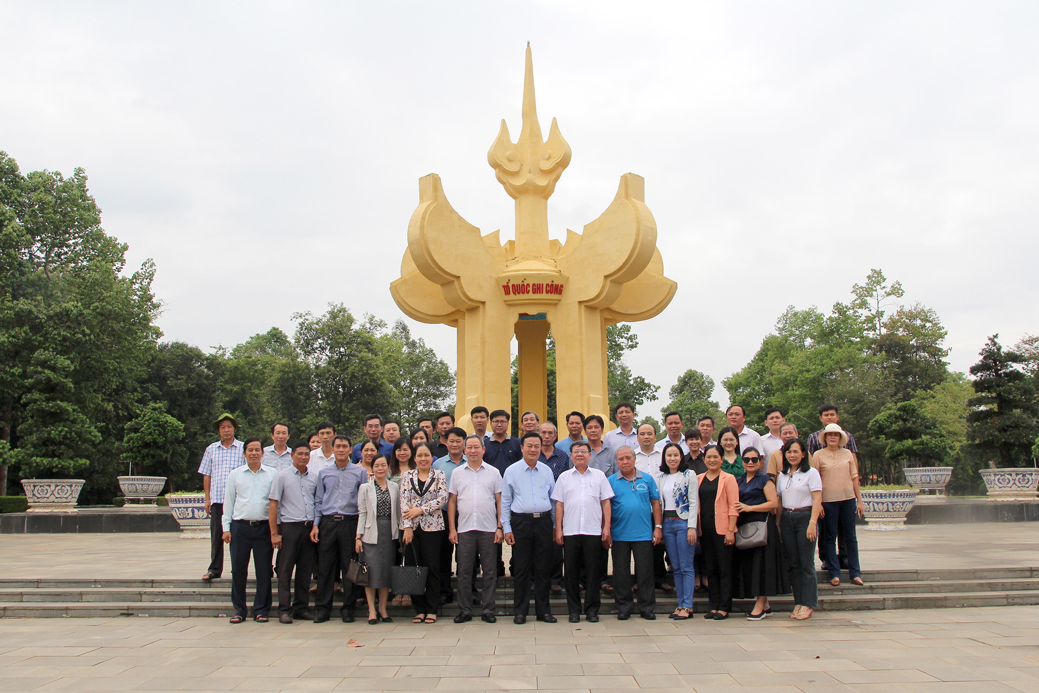 Đoàn chụp ảnh lưu niệm tại Đài tưởng niệm Khu di tích lịch sử Tà Thiết (Ảnh: H. Hào).